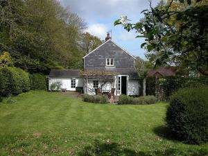 uma casa com um quintal com um campo de relva em Gun Hill Cottage em Horam