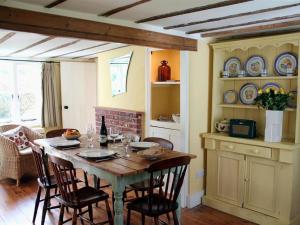 comedor con mesa y sillas en la cocina en Gun Hill Cottage en Horam