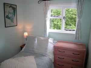 A bed or beds in a room at Gun Hill Cottage