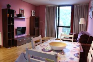 ein Wohnzimmer mit einem Tisch und ein Zimmer mit rosa Wänden in der Unterkunft Adrimarcangas 2 in Cangas de Onís