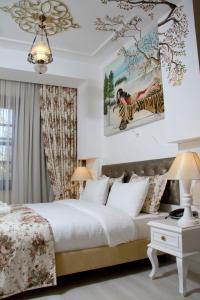ein Schlafzimmer mit einem Bett und einem Wandgemälde in der Unterkunft Kaleiçi Ozkavak Hotel in Antalya