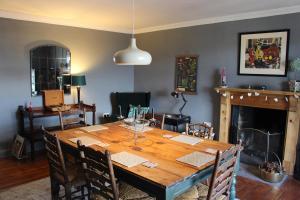 uma sala de jantar com uma mesa de madeira e uma lareira em Clan Ross - 3 bed, spacious Georgian home em Stirling