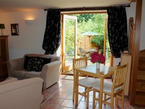 a living room with a table and chairs and a window at The Cider Barn in Flaxley