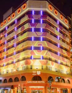 San Hua Hotel في كاوشيونغ: مبنى الفندق عليه انوار ارجوانيه