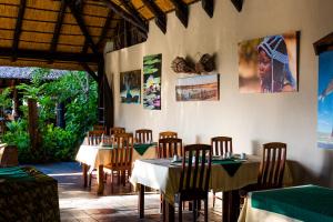 une salle à manger avec des tables et des chaises dans un restaurant dans l'établissement Namushasha River Campsite, à Kongola