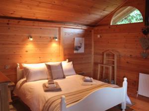 a bedroom with a bed in a log cabin at Treetops in Parracombe