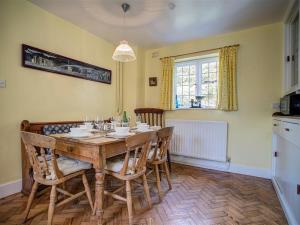 a dining room with a wooden table and chairs at Foley's Cottage in Warminster