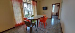 a dining room with a table and chairs at Allamanda Apartments - 100m Bain Boeuf Beach in Bain Boeuf