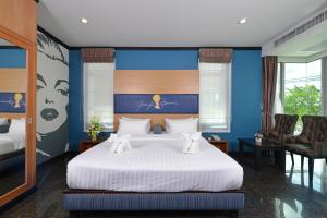 a bedroom with a large white bed with blue walls at The River Scene in Krabi