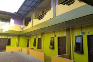 a room with yellow and green walls and doors at OYO 3487 Es Em Je Residence in Lubukpakam