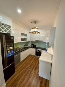 a kitchen with white cabinets and a black refrigerator at SHP Plaza Khanh Phong Homestay in Hai Phong