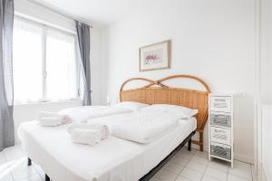 um quarto com 2 camas e lençóis brancos em Casa Pelér em Nago-Torbole
