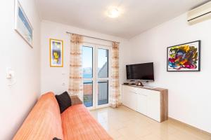 a living room with a couch and a television at Apartments Peco in Korčula