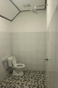 een badkamer met een toilet en een douchecabine bij Umah De Arlika UBUD in Ubud