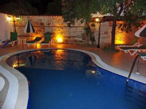 a swimming pool in a backyard at night at Kaleiçi Ozkavak Hotel in Antalya
