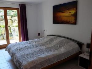 a bedroom with a bed and a picture on the wall at Ferienwohnung Susanne Würtenberger in Öhningen