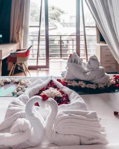 two white swans sitting on a bed in a room at Mola2 Resort Gili Air in Gili Islands +37 photos