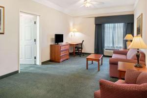 a hotel room with a couch and a desk at La Quinta Inn and Suites Fort Myers I-75 in Fort Myers