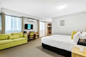 雪梨的住宿－Quality Inn Sunshine Haberfield，酒店客房设有床和黄色沙发