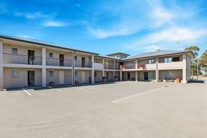 un estacionamiento vacío frente a un motel en The Suites Ashburton, en Ashburton