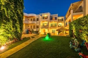 a large building with a green light in the yard at Oasis Beach Hotel in Skala
