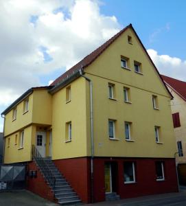 a yellow building with stairs on the side of it at Ferienzimmer Gersprenztal in Reichelsheim