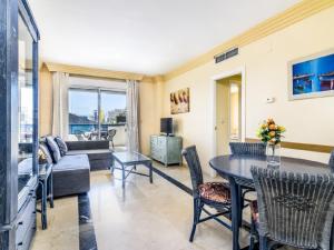 uma sala de estar com uma mesa e cadeiras e um sofá em Apartamento 306 em Marbella