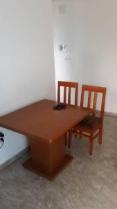 une table en bois et deux chaises installées à côté dans l'établissement OCEAN-SI MAnsion, à Kribi