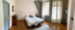 ein Schlafzimmer mit einem weißen Bett und einem Fenster in der Unterkunft Les Tilleuls in Saint-Georges-de-Luzençon