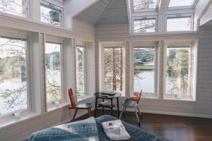 a room with windows and a table and chairs at Granö Beckasin in Granön
