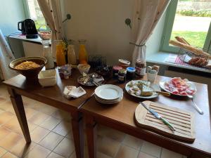 una mesa de madera con platos de comida. en Les Tilleuls, en Saint-Georges-de-Luzençon
