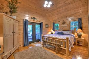 1 dormitorio en una cabaña de madera con cama y banco en Aska Adventure Lodge, en Blue Ridge