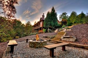 Una fogata frente a una casa con bancos en Aska Adventure Lodge, en Blue Ridge