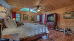 Dormitorio con cama y TV en una cabina en Above and Beyond, en Blue Ridge