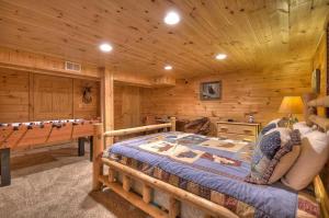 a log cabin bedroom with a bed and a pool table at Big Buck Lodge in Blue Ridge