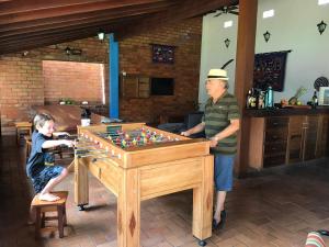 a man and a young boy playing with a chess board at RC HOUSE in Chapada dos Guimarães