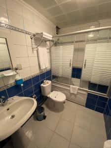 a bathroom with a sink and a toilet and a shower at Anzac Hotel in Çanakkale