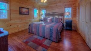 Un dormitorio con una cama en una cabaña de troncos en Black Dog of Blue Ridge, en Blue Ridge