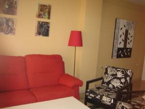 a living room with a red couch and a chair at Apartamento 329 in Marbella
