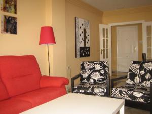 sala de estar con sofá rojo y silla en Apartamento 329, en Marbella