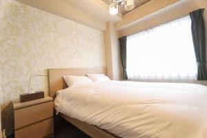 船橋的住宿－Chiba Nishi-funabashi Residence #MU1，卧室配有白色的床和窗户。