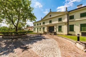 una vista exterior de un gran edificio con un árbol en Villa Solatia, en Caldogno