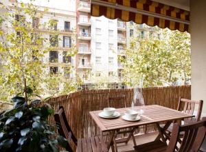 y balcón con mesa y sillas de madera. en GAUDI Barcelonastuff Apartments, en Barcelona