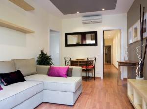 sala de estar con sofá blanco y almohadas rosas en GAUDI Barcelonastuff Apartments, en Barcelona