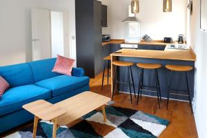 索爾泰爾的住宿－Salts House - Contemporary Apartments in Saltaire - Free On-Street Parking，一间带蓝色沙发的客厅和一间厨房