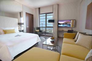 a hotel room with a bed and a couch at Centro Corniche Al Khobar by Rotana in Al Khobar