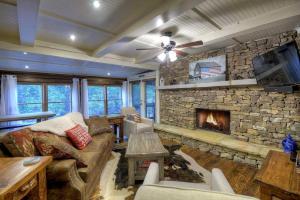 a living room with a large stone fireplace at Creekside R&R in Blue Ridge