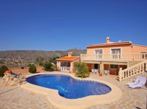 a villa with a swimming pool in front of a house at Villa Gravetes - Plusholidays in Teulada