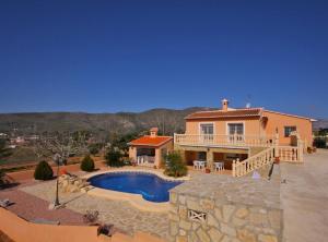 a large house with a swimming pool in front of it at Villa Gravetes - Plusholidays in Teulada