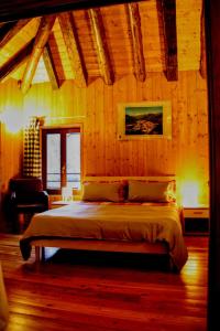 a bedroom with a bed in a room with wooden walls at Casa Rimasco in Rimasco